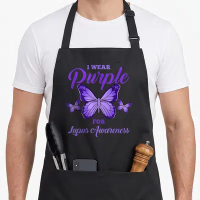 Lupus hiking lover apron - Purple butterfly illustration with I WEAR Purple FOR Lupus Awareness text — shown on a black cotton canvas apron against a white background