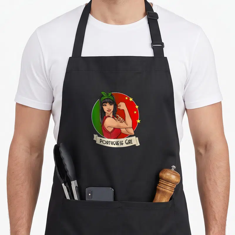 Retro portugal portuguese apron - Cartoon woman flexing arm on green red circle with five yellow stars and PORTUGUESE — shown on a black cotton canvas apron against a white background