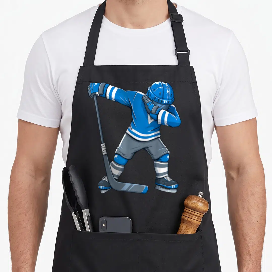 Dress hockey apron - Cartoon hockey player in blue and grey gear dabbing with a stick — shown on a black cotton canvas apron against a white background