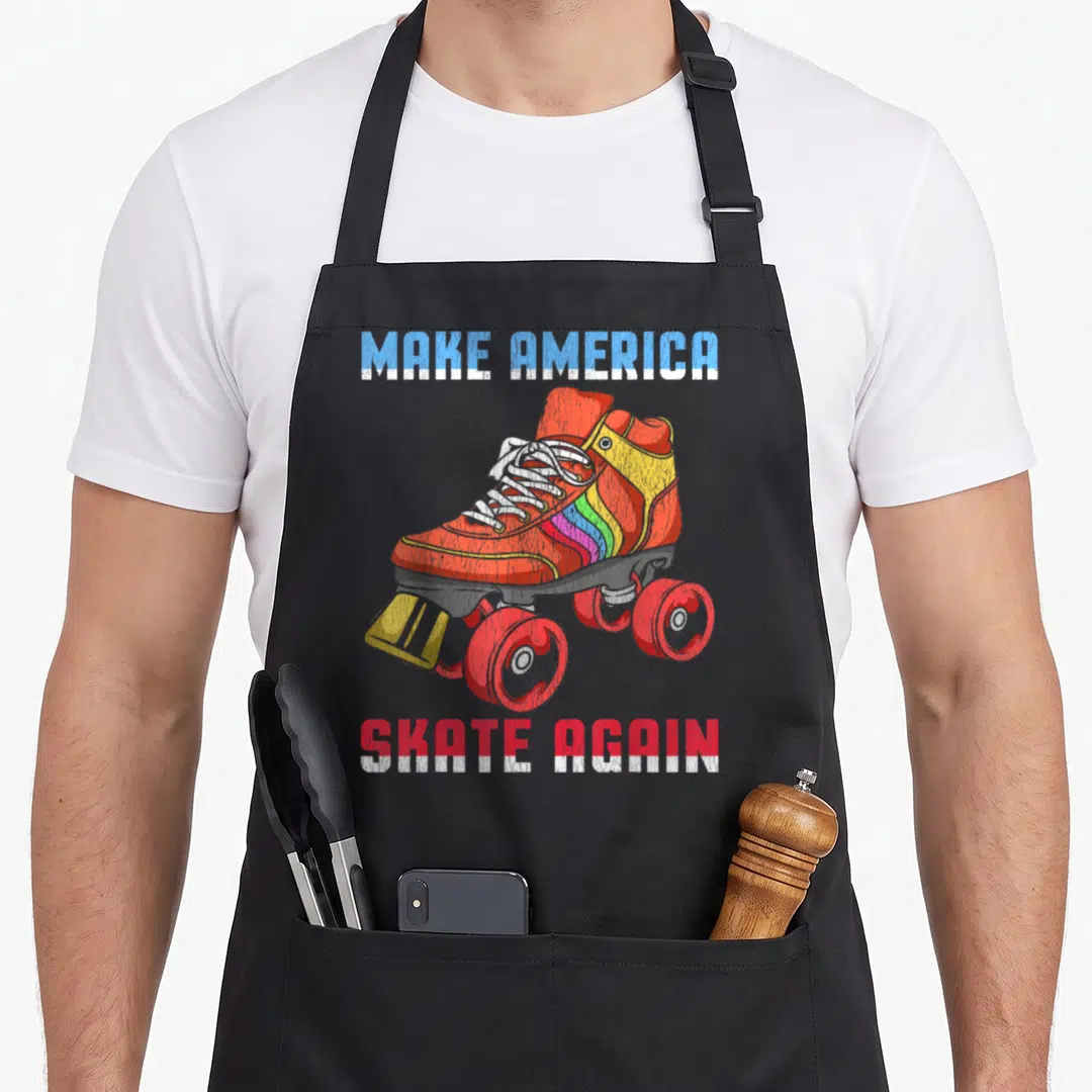 Roller 80s apron - Distressed quad skate graphic with MAKE AMERICA SKATE AGAIN text in red and blue block letters — shown on a black cotton canvas apron against a white background
