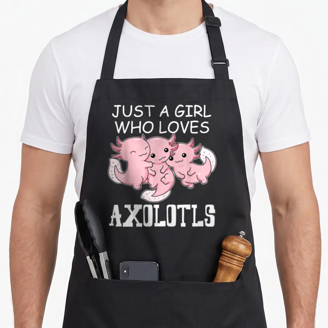 Vintage axolotl kawaii apron - Three pink cartoon axolotls hugging under white text reading JUST A GIRL WHO LOVES — shown on a black cotton canvas apron against a white background