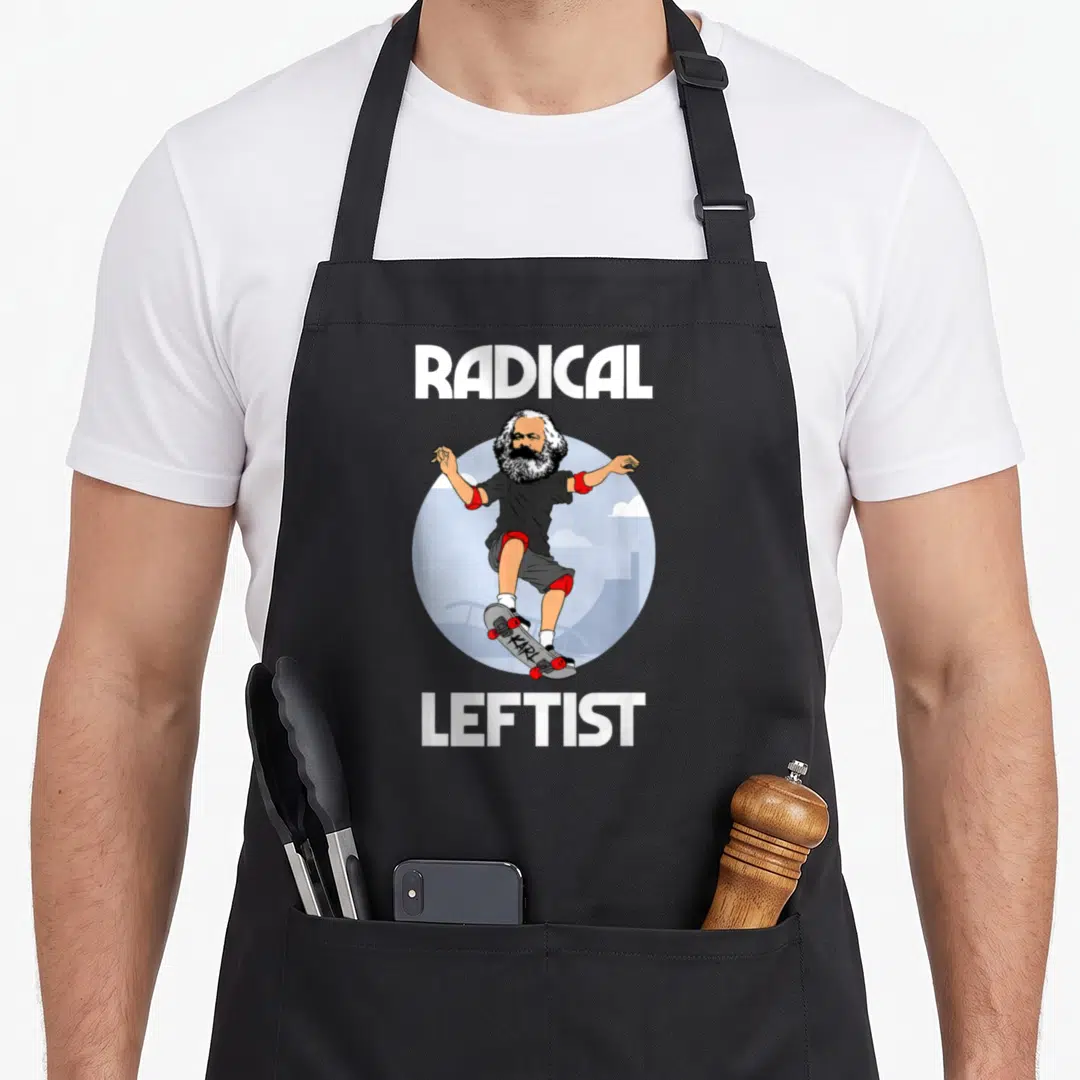 Karl skateboarding apron - Cartoon Karl Marx skateboarding with text RADICAL LEFTIST in white red and blue — shown on a black cotton canvas apron against a white background