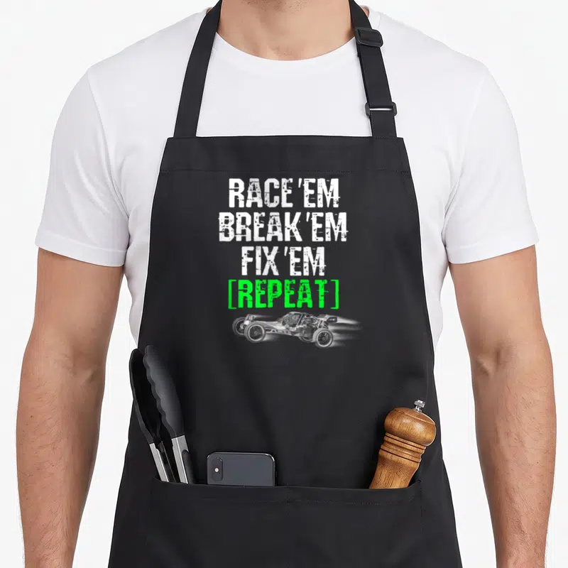 Race break car apron - Stacked white and green text above a grey remote control race car with motion blur — shown on a black cotton canvas apron against a white background