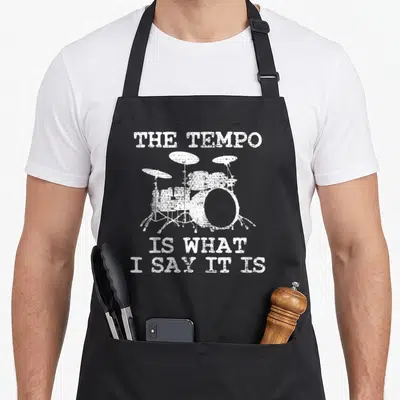Drum trumpeter apron - Distressed white drum kit flanked by text reading THE TEMPO IS WHAT I SAY IT IS — shown on a black cotton canvas apron against a white background
