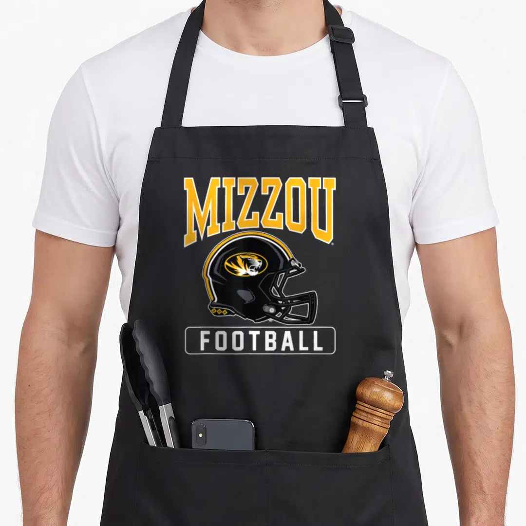 Missouri football apron - Arched MIZZOU text above black helmet with tiger head and white FOOTBALL label — shown on a black cotton canvas apron against a white background