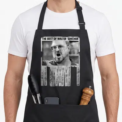 Lebowski novelty apron - Walter Sobchak photo and quotes on torn paper strips in black and white — shown on a black cotton canvas apron against a white background