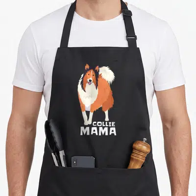 Collie mama dog apron - Cartoon Rough Collie standing above white text reading COLLIE MAMA on black fabric — shown on a black cotton canvas apron against a white background