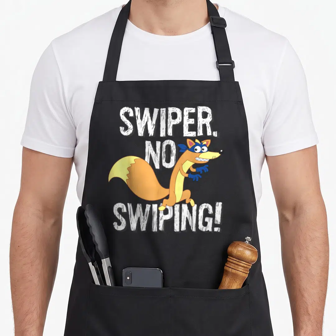 Dora fox aprons - Cartoon fox with blue mask between white text reading SWIPER NO SWIPING — shown on a black cotton canvas apron against a white background
