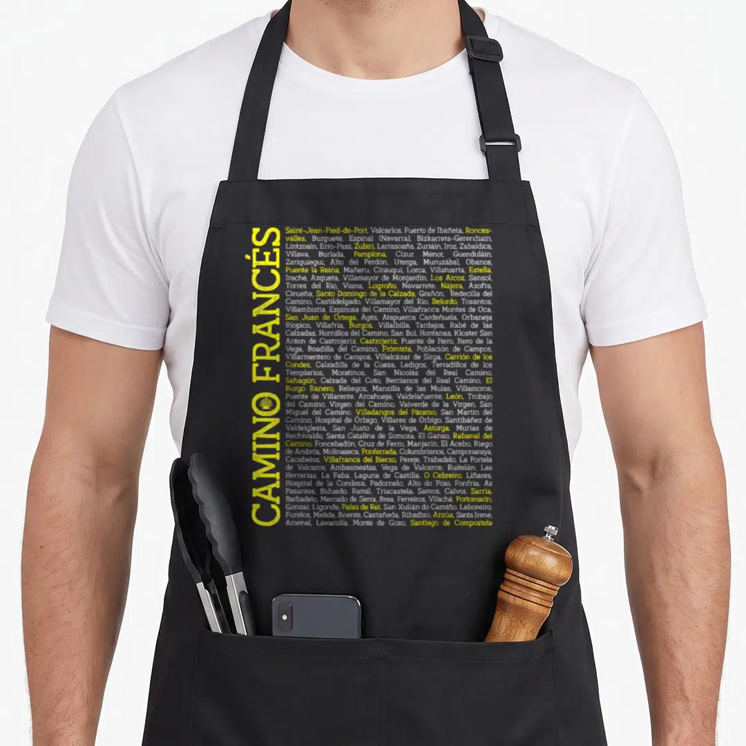 Camino scallop apron - Vertical yellow CAMINO FRANCÉS text next to list of Spanish towns and yellow scallop shell icon — shown on a black cotton canvas apron against a white background