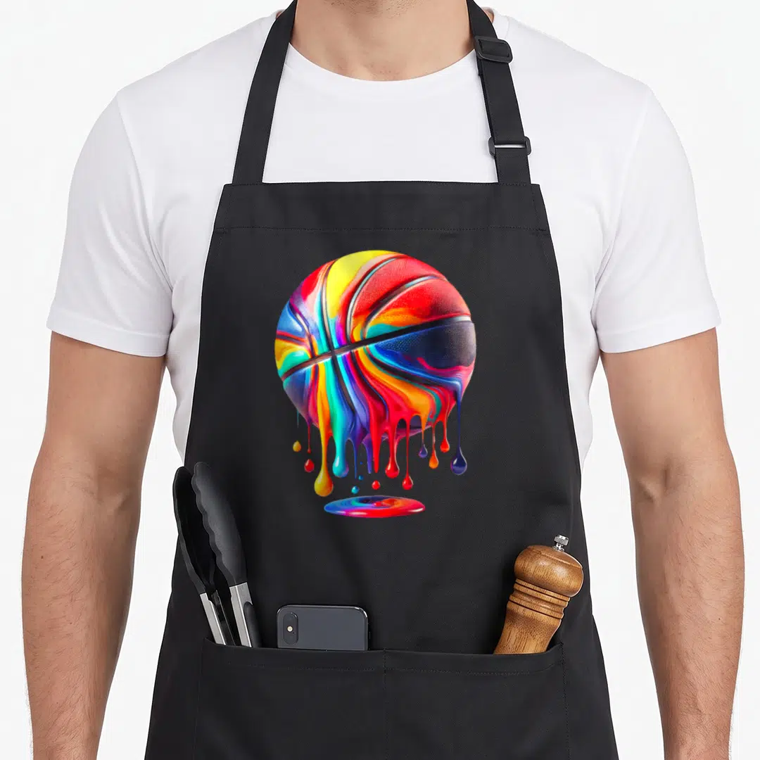 Ball drip apron - Rainbow basketball with red yellow blue green purple paint dripping into puddle — shown on a black cotton canvas apron against a white background