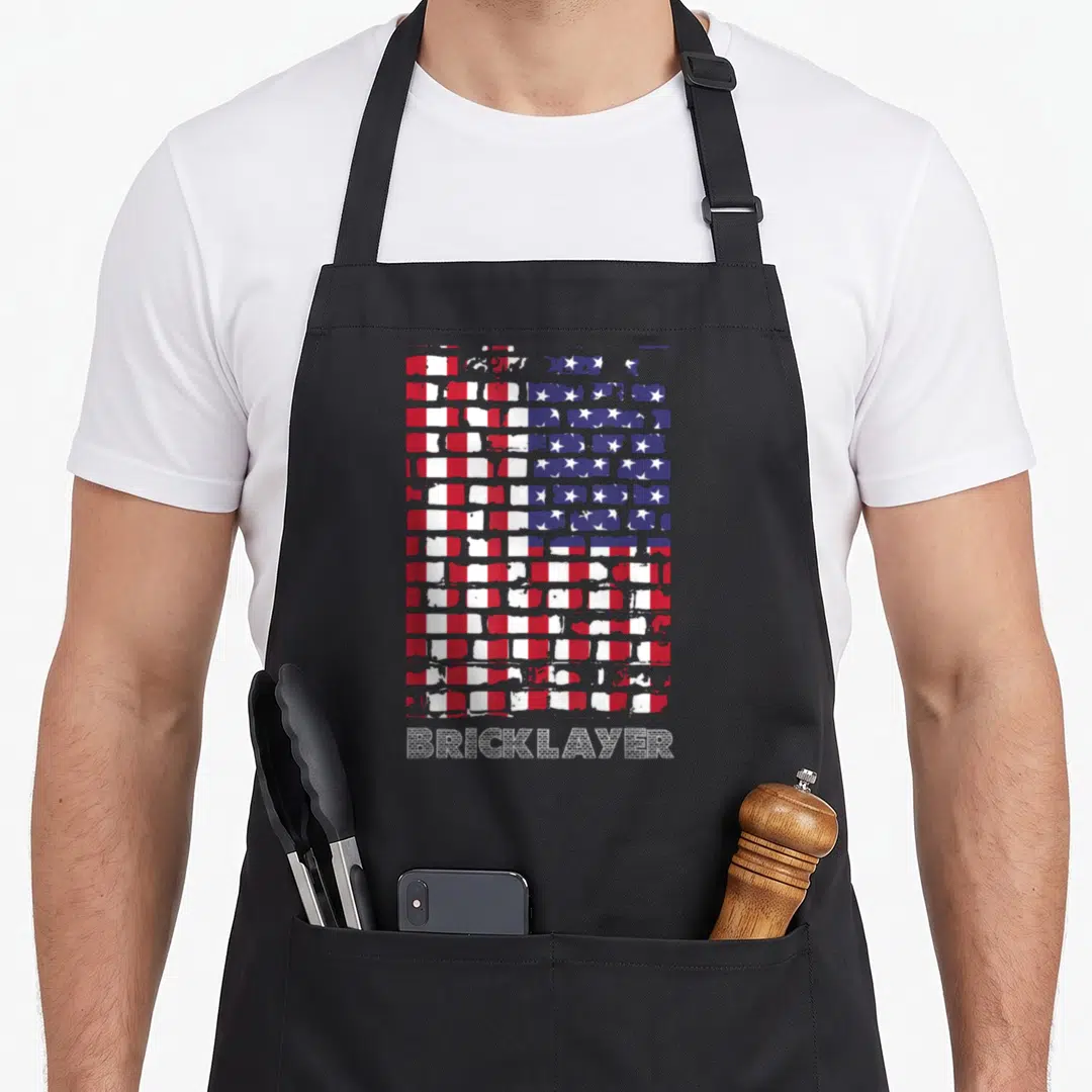 Bricklayer patriotic apron - Distressed brick wall in red white and blue with textured BRICKLAYER text below — shown on a black cotton canvas apron against a white background
