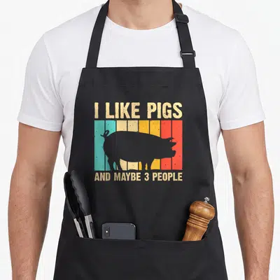 Pig animal farm aprons - Retro pig silhouette on colored stripes with I Like Pigs And Maybe 3 People text — shown on a black cotton canvas apron against a white background