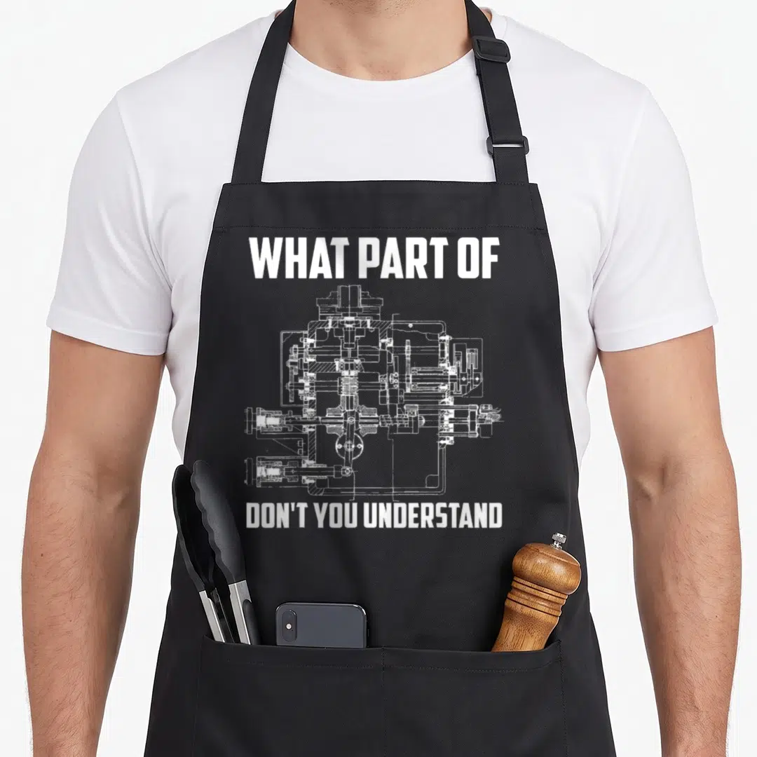 Part nerd apron - White technical drawing of a hydraulic valve cross-section between bold text lines — shown on a black cotton canvas apron against a white background