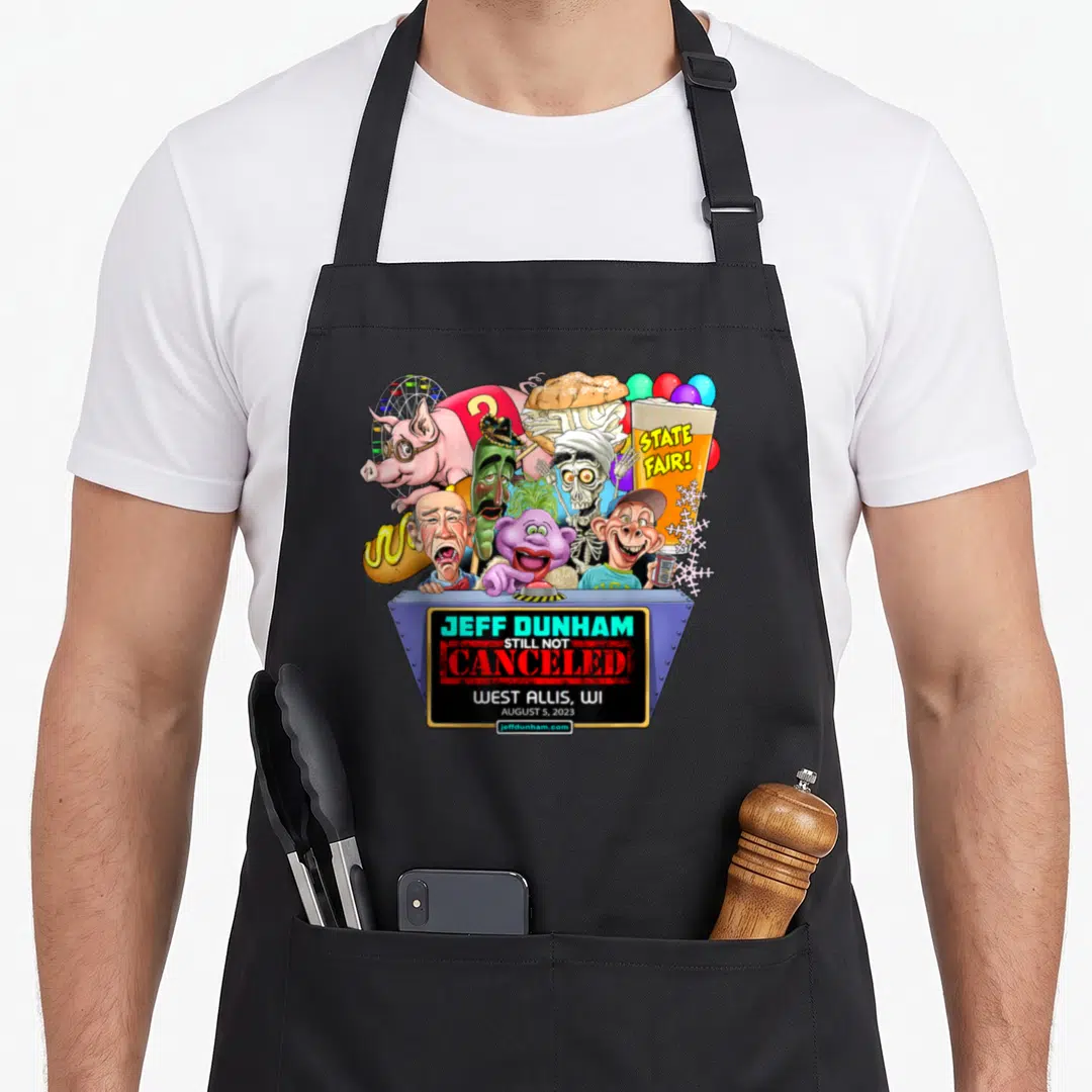 West wi aprons - Jeff Dunham Still Not Canceled cartoon puppets fair food grey stage red green yellow purple — shown on a black cotton canvas apron against a white background