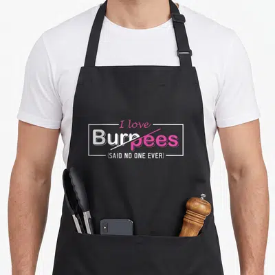 Burpee emu dad apron - I love Burpees Said No One Ever text with pink strike-through and white frame — shown on a black cotton canvas apron against a white background