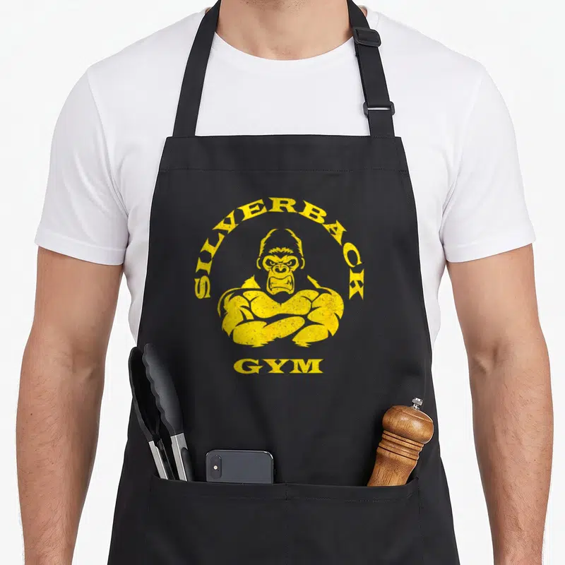 Gorilla silverback aprons - Yellow distressed gorilla graphic with SILVERBACK GYM text — shown on a black cotton canvas apron against a white background