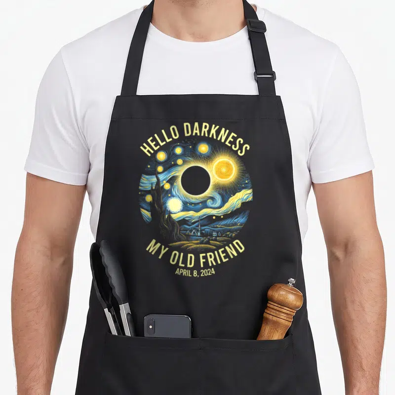 Hello van gogh apron - Starry Night solar eclipse circle with Hello Darkness My Old Friend text and April 8 2024 date — shown on a black cotton canvas apron against a white background