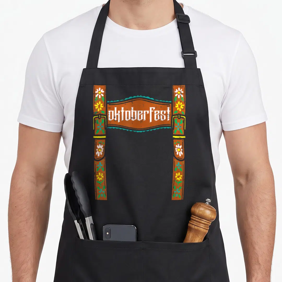 Costume oktoberfest lederhosen apron - Cartoon brown suspenders with flowers and buckles framing Oktoberfest text — shown on a black cotton canvas apron against a white background