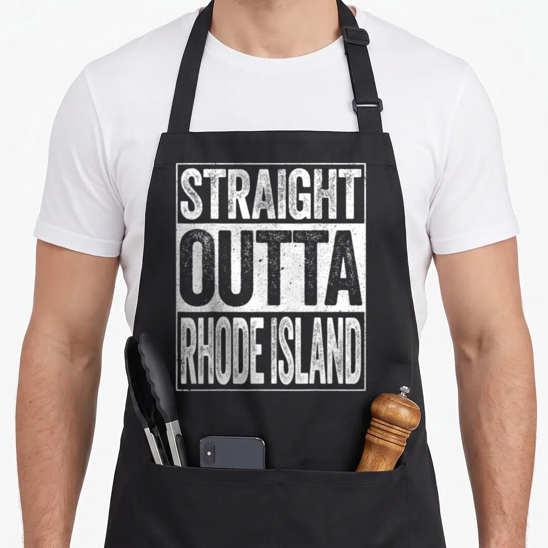 Straight providence apron - Stacked white and grey text reading STRAIGHT OUTTA RHODE ISLAND inside a rectangular border — shown on a black cotton canvas apron against a white background
