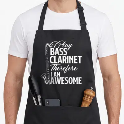 Play clarinet apron - White bass clarinet graphic beside stacked text reading I Play Bass Clarinet Therefore I Am — shown on a black cotton canvas apron against a white background