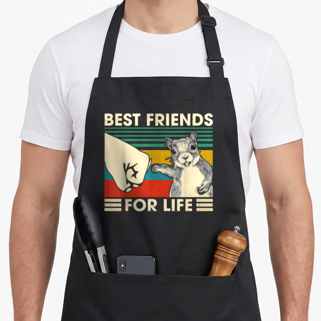 Squirrel friends apron - Retro squirrel and human fist bump with striped background and text best friends for life — shown on a black cotton canvas apron against a white background
