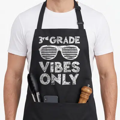 3rd grade vibes apron - White distressed shutter shades between 3rd GRADE and VIBES ONLY text — shown on a black cotton canvas apron against a white background