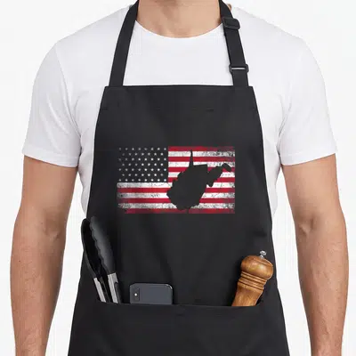 West 4th of july apron - Grey West Virginia silhouette over distressed red white blue USA flag pattern — shown on a black cotton canvas apron against a white background