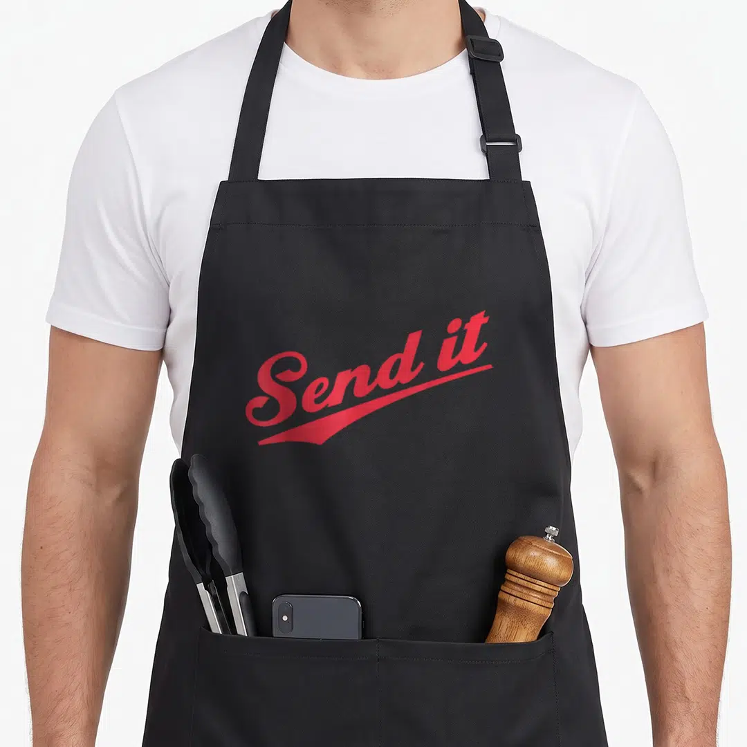 Send beer apron - Red cursive text reading Send it with a matching red swoosh underline on black fabric — shown on a black cotton canvas apron against a white background