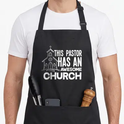 Church clergy apron - White line-art church illustration next to bold text reading This Pastor Has An Awesome Church — shown on a black cotton canvas apron against a white background