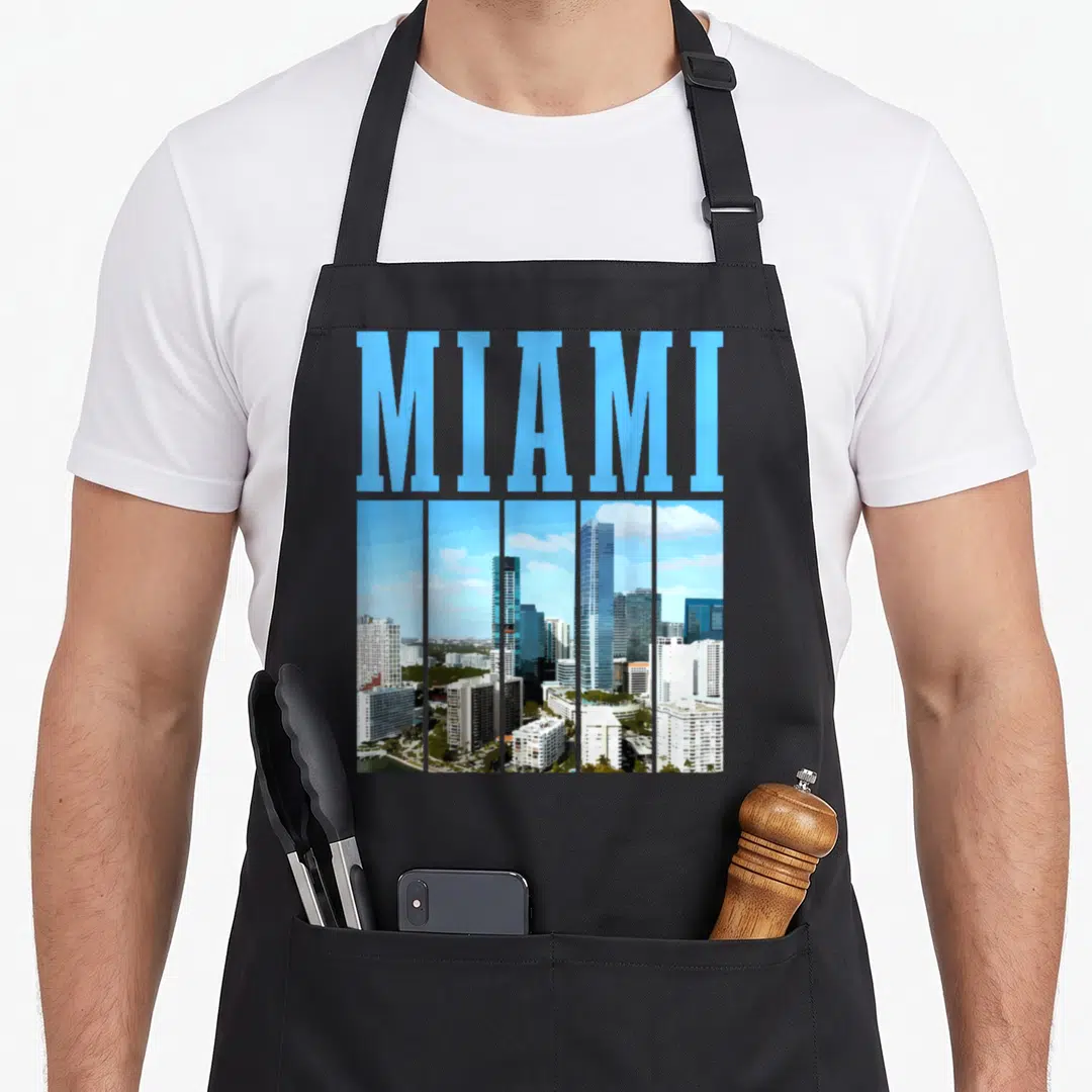Miami skyline florida pride apron - Blue MIAMI text above a city skyline photo divided into five vertical strips — shown on a black cotton canvas apron against a white background