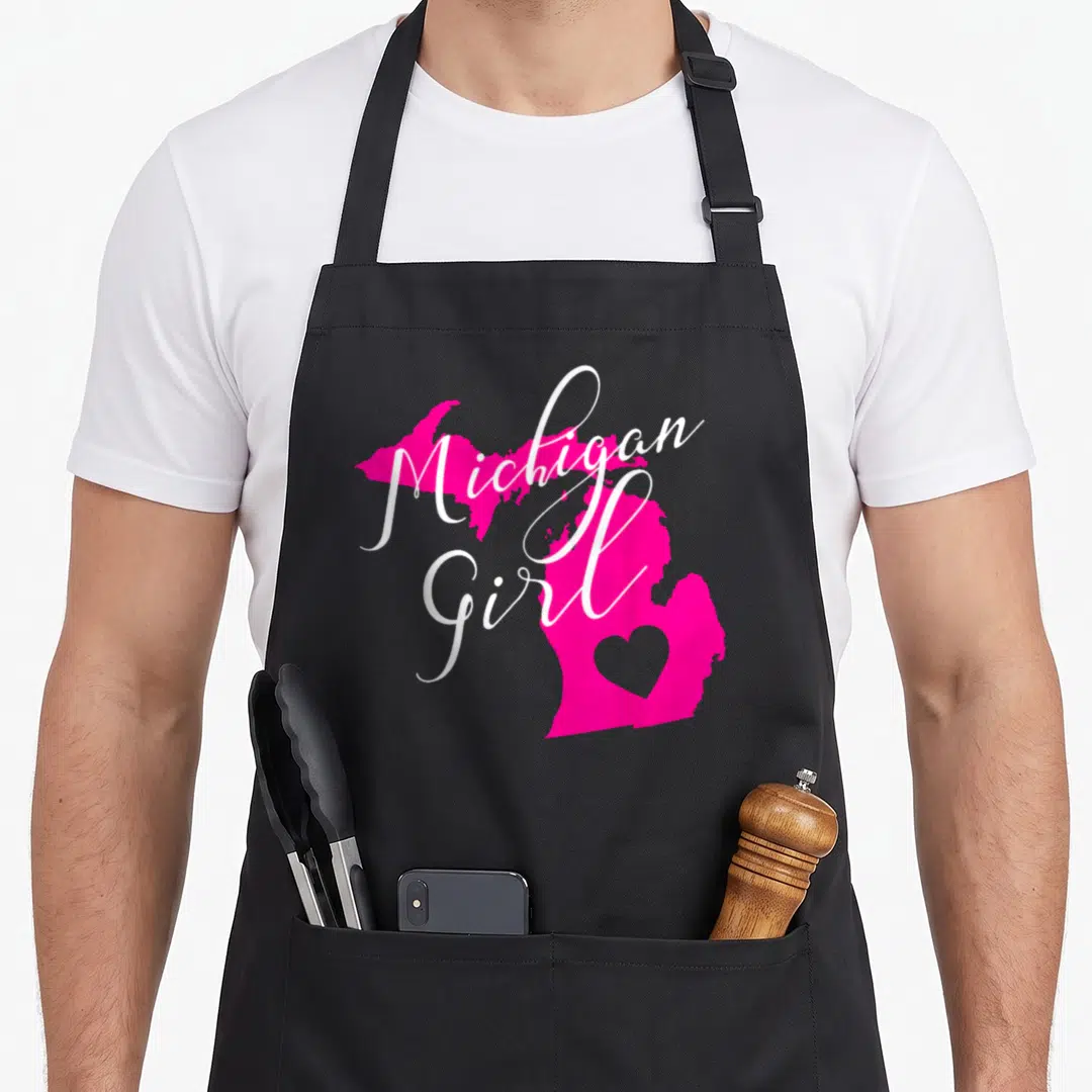 State michigan boy apron - Pink Michigan map silhouette with white Michigan Girl script and heart cutout in lower — shown on a black cotton canvas apron against a white background
