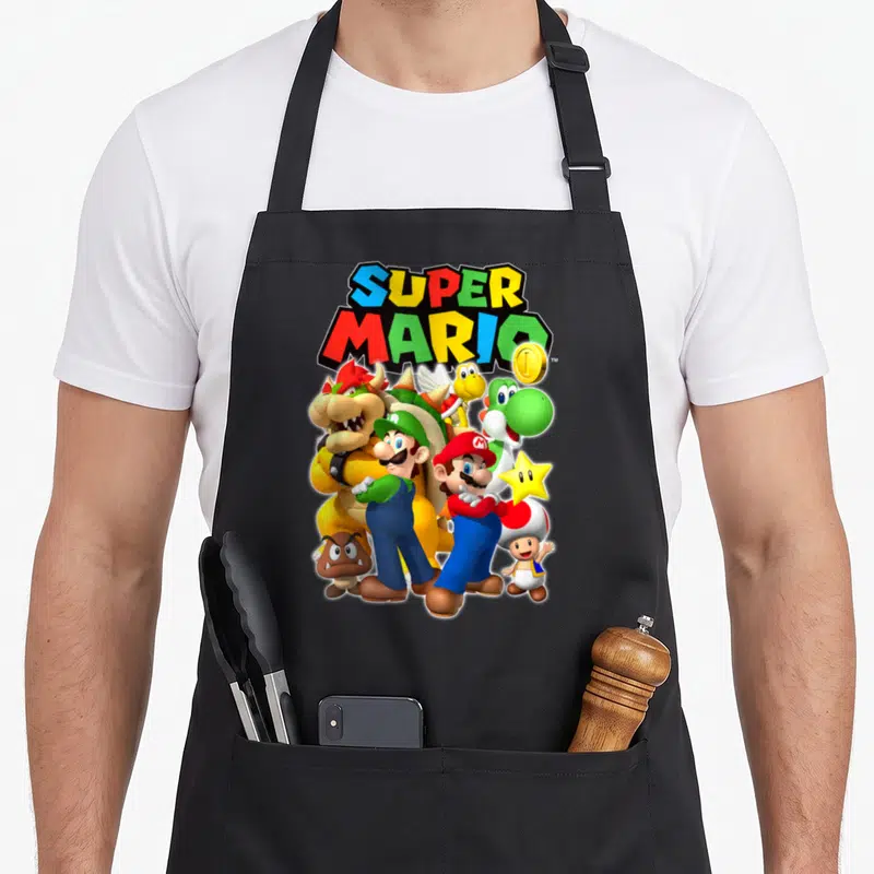 Original shot apron - Super Mario logo with Mario, Luigi, Bowser, Yoshi, Toad, Goomba, and a gold coin in cartoon art — shown on a black cotton canvas apron against a white background