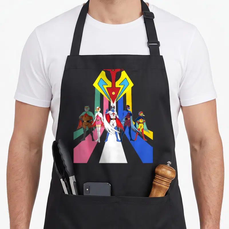 Gatachaman planet apron - Five cartoon superheroes under yellow-red logo with colored vertical stripes — shown on a black cotton canvas apron against a white background