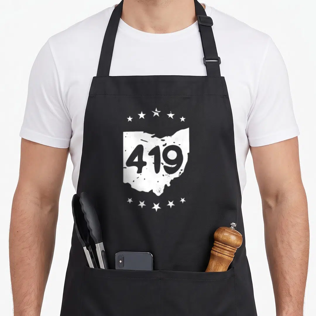 Sandusky pride apron - White Ohio map silhouette containing grey 419 text with two rows of five stars above and below — shown on a black cotton canvas apron against a white background