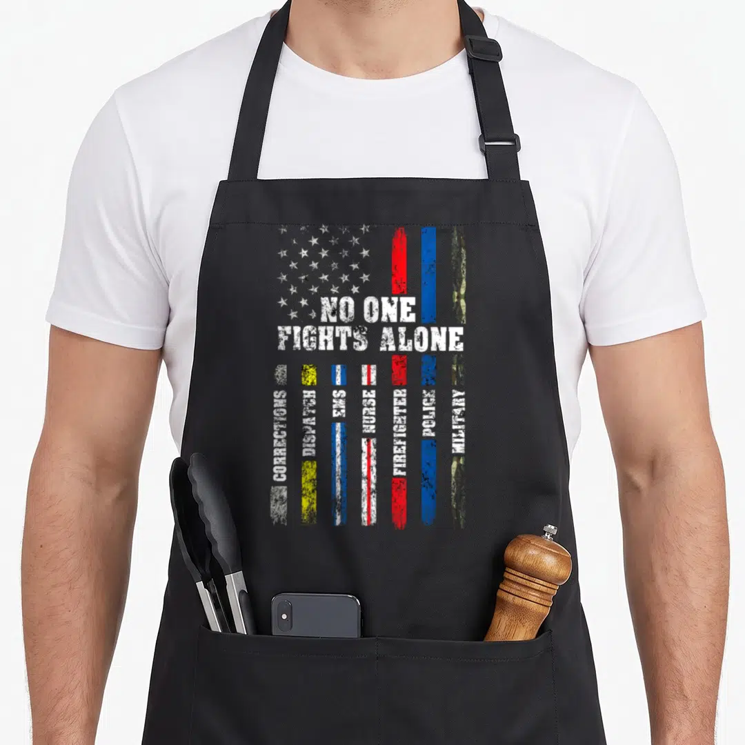 Police american flag apron - Distressed USA flag with NO ONE FIGHTS ALONE text above seven vertical stripes listing — shown on a black cotton canvas apron against a white background