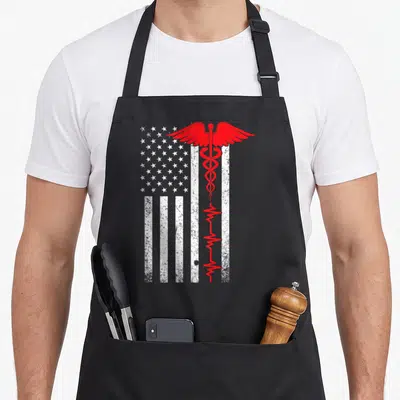 Thin nurse apron - Red caduceus and heartbeat line over distressed white USA flag — shown on a black cotton canvas apron against a white background