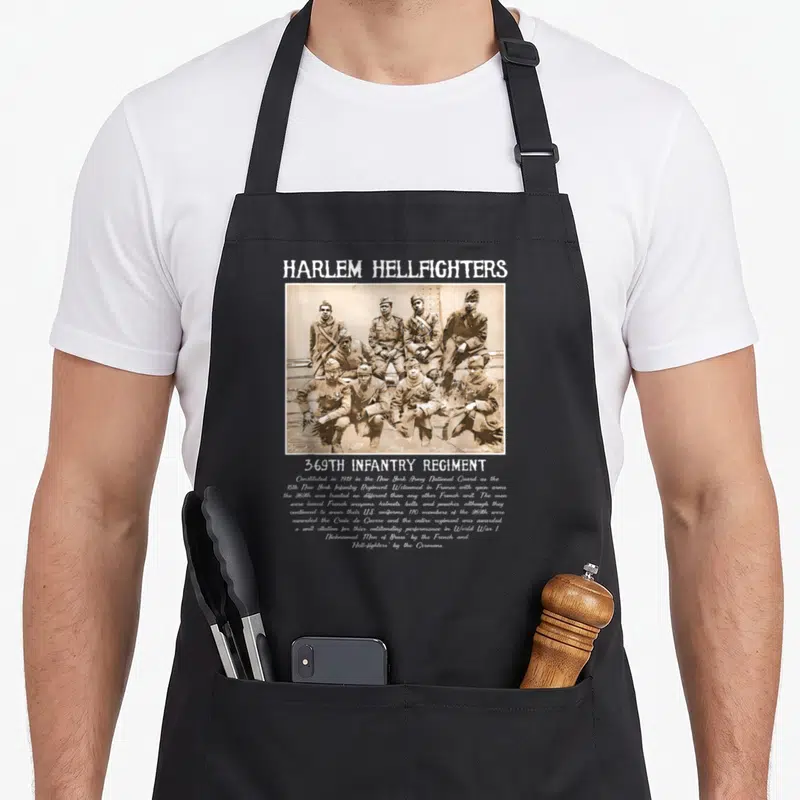 Harlem military apron - Sepia photo of 369th Infantry soldiers with white historical text — shown on a black cotton canvas apron against a white background