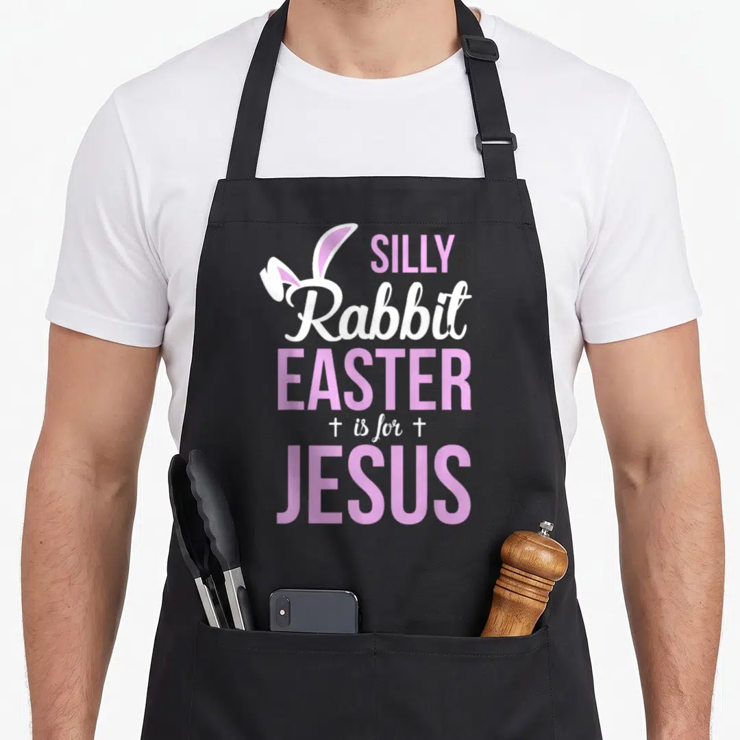 Silly rabbit apron - Pink and white text reading Easter is for Jesus with bunny ears and two crosses flanking — shown on a black cotton canvas apron against a white background