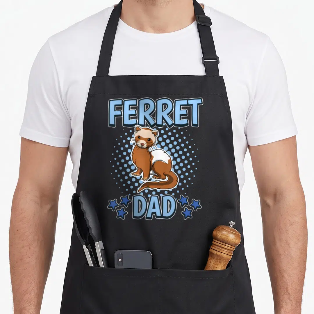 Cute ferret father day apron - Cartoon brown and white ferret with blue text FERRET DAD and star graphics — shown on a black cotton canvas apron against a white background
