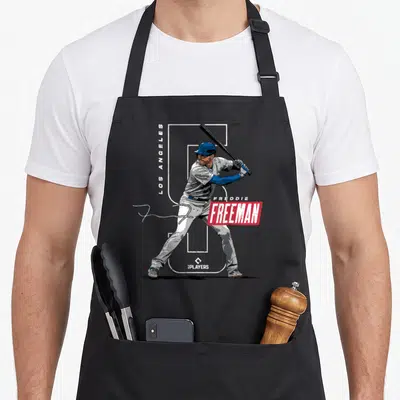 Champ baseball apron - Baseball player holding bat behind white number 5 with vertical Los Angeles text and red Freeman — shown on a black cotton canvas apron against a white background