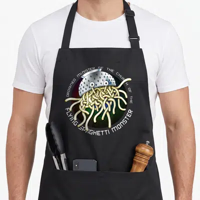 Ordained church aprons - Cartoon Flying Spaghetti Monster in silver colander with ordained minister text in circle — shown on a black cotton canvas apron against a white background