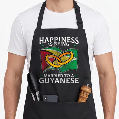 Guyana heritage aprons - Distressed Guyana flag with gold rings and text HAPPINESS IS BEING MARRIED TO A GUYANESE — shown on a black cotton canvas apron against a white background