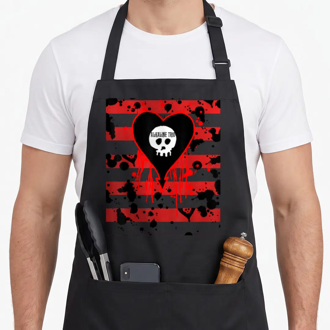 Alkaline bloody apron - Black heart with white skull and ALKALINE TRIO text over red and grey stripes with splatters — shown on a black cotton canvas apron against a white background