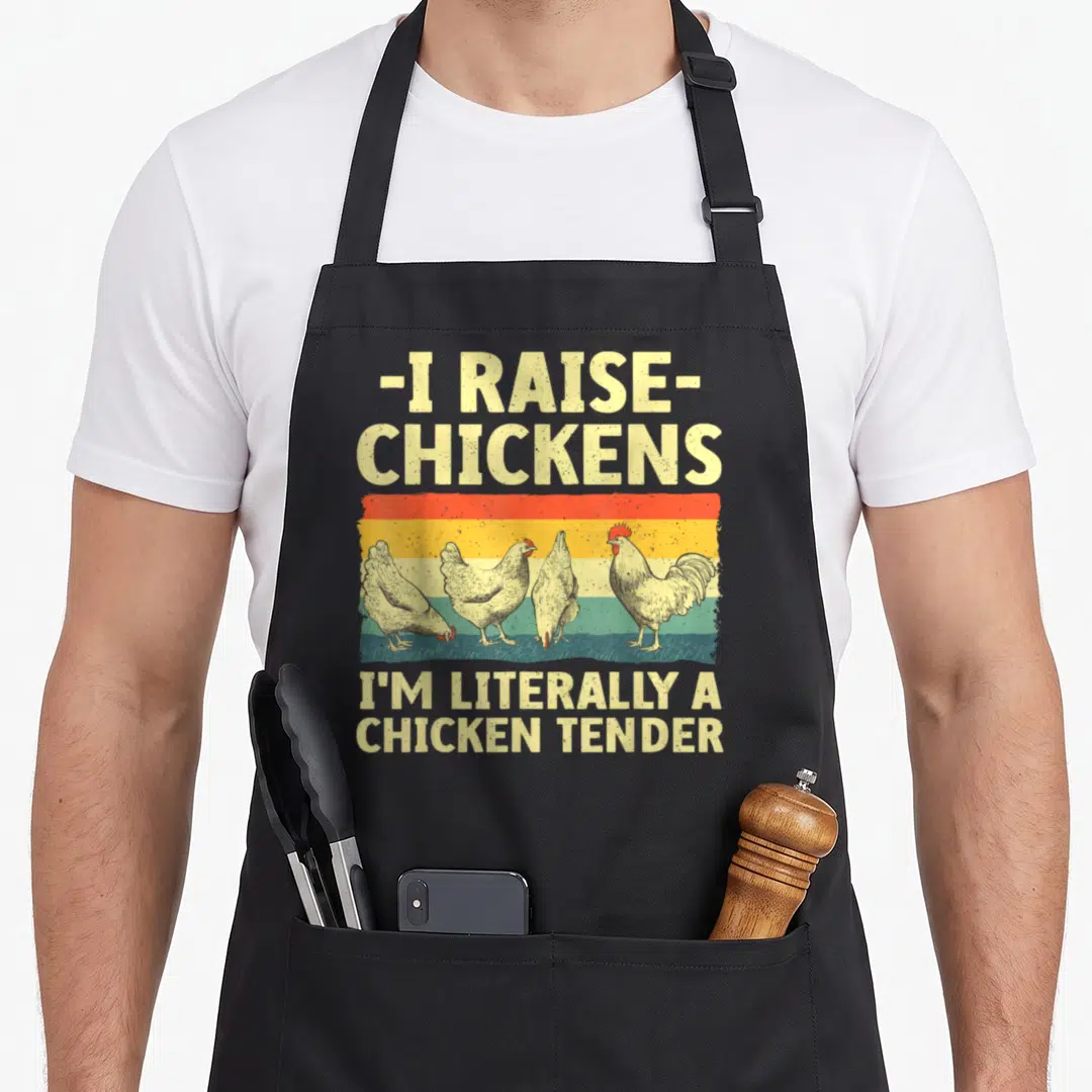 Tender farmer apron - Retro text I raise chickens I'm literally a chicken tender over four chickens on striped — shown on a black cotton canvas apron against a white background