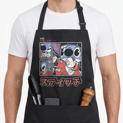 Kanji stitch apron - Three comic panels of Stitch with 626 and Japanese text in blue red white — shown on a black cotton canvas apron against a white background