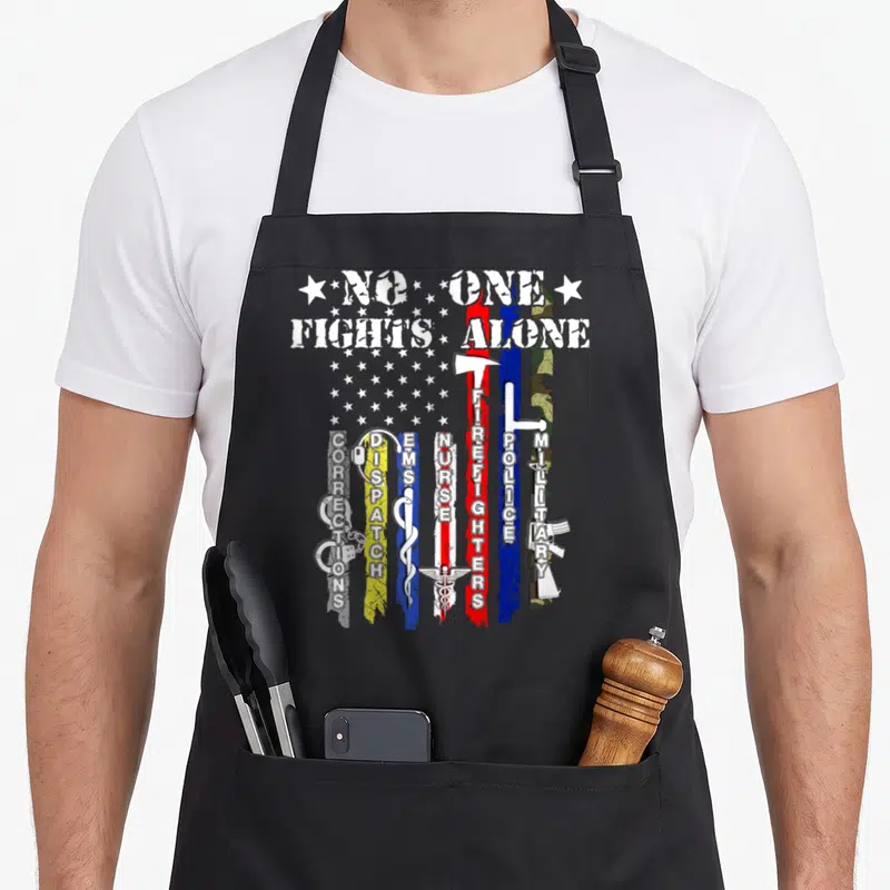 Fight police apron - NO ONE FIGHTS ALONE text above vertical colored stripes with symbols for police, fire — shown on a black cotton canvas apron against a white background