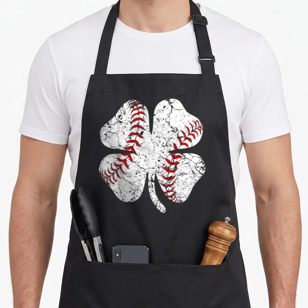 Baseball st patrick day aprons - White distressed four-leaf clover with red baseball stitching on black fabric — shown on a black cotton canvas apron against a white background