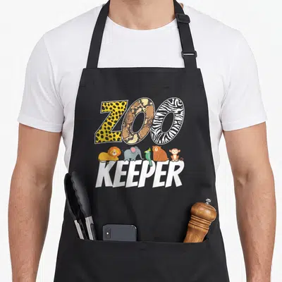 Animal african apron - ZOO KEEPER text with five cartoon animals including lion elephant parrot bear monkey and animal — shown on a black cotton canvas apron against a white background