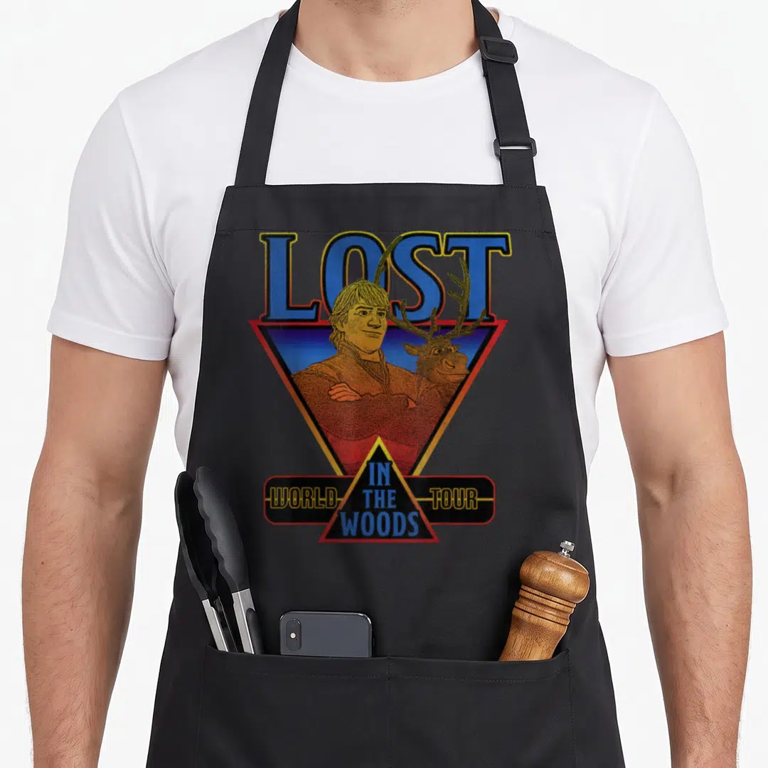 Frozen wood apron - Retro LOST IN THE WOODS WORLD TOUR text with man and deer in geometric triangles — shown on a black cotton canvas apron against a white background