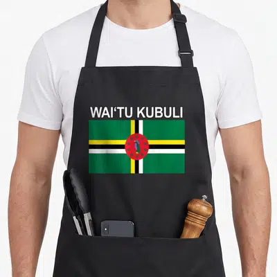 Waitu island pride apron - WAI'TU KUBULI text above a rectangular Dominica flag with green white yellow and red colors — shown on a black cotton canvas apron against a white background
